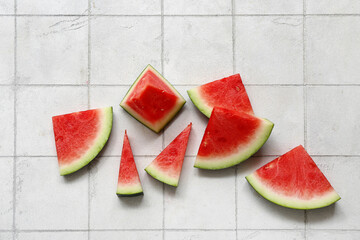 Pieces of fresh watermelon on white tile background