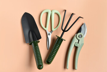 Set of gardening tools on beige background