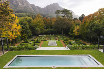 General view of beautiful home garden with swimming pool and trees near mountains landscape