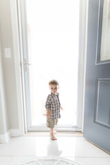 Fototapeta na wymiar Toddler Boy in front of Bright Light from Door