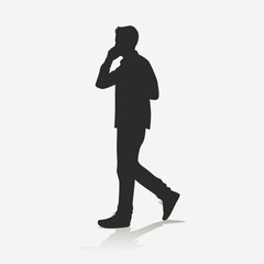 Silhouette of man walking while calling