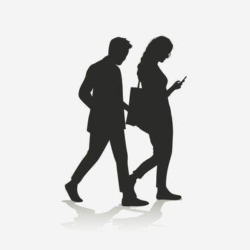 Silhouette of a couple walking, holding cellphones