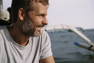 A middle-aged man is traveling by sea in a boat. The Lovina Bali