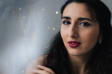 Close-up of a girl on a gray background with twinkle lights