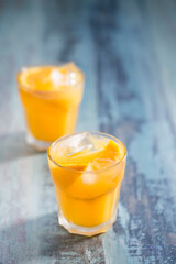 Orange juice on a rustic wooden table.