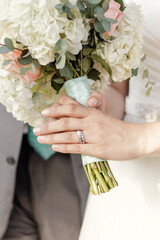 Close up of bride's wedding ring while holding bridal bouquet