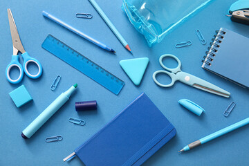 Different school stationery and notebooks on blue background