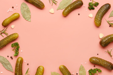 Frame made of pickled cucumbers and different spices on red background