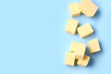 Pieces of fresh butter on blue background