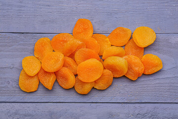 Tasty dried apricots on blue wooden background