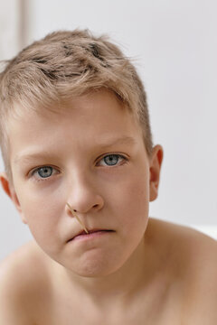 Close-up portrait of rebellious boy holding toothpick with his lips
