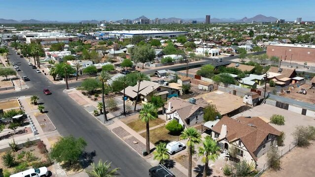 Housing in suburb neighborhood of large city in desert of USA. Aerial establishing shot of stucco houses with palm trees and dry climate.