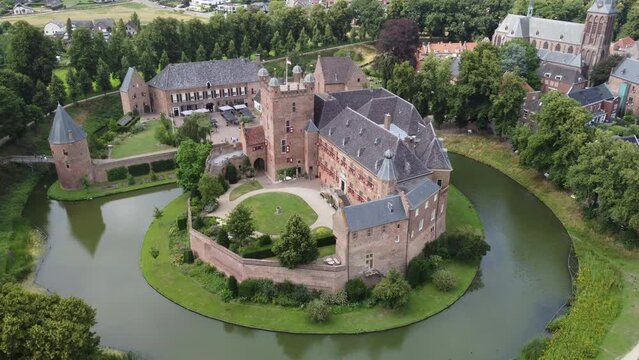 kasteel huis bergh, the netherlands: aerial view traveling in the beautiful castle and appreciating the moat, the towers and the nearby church. In the Netherlands on a sunny day.