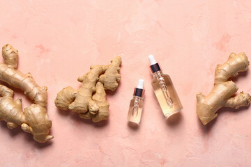 Bottles of ginger cosmetic oil on pink background