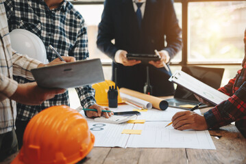 Engineer teams meeting working together wear worker helmets hardhat on construction site in modern city.