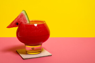 Glass of tasty watermelon juice on colorful background