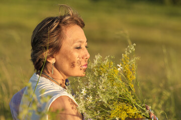 An elderly woman, sitting in a summer meadow with wild flowers, reveals the wisdom and beauty of aging, accepting her age