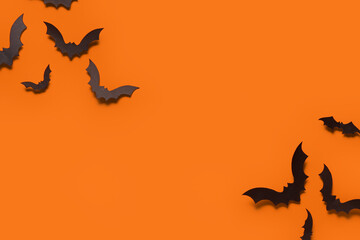Paper bats for Halloween party on orange background