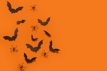 Paper bats and spiders for Halloween party on orange background