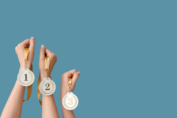 Female hands with medals on blue background