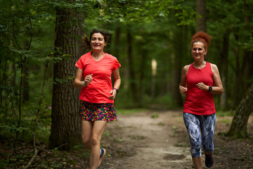 Fototapeta premium Happy ladies jogging in the forest