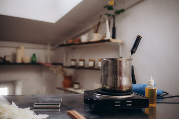 wax in a ladle is melted on a gas stove