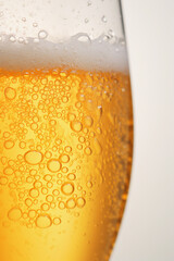 Closeup with fresh beer in the glass. background white and gold