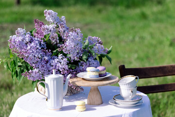 bouquet of lilacs in a vase and cakes