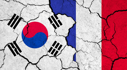 Flags of South Korea and France on cracked surface - politics, relationship concept