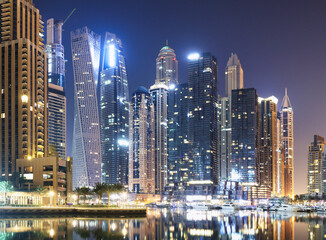 Fototapeta na wymiar Promenade and canal in Dubai Marina at night with luxury skyscrapers around,United Arab Emirates