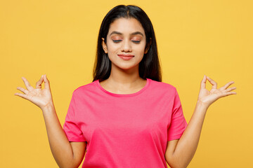 Young spiritual Indian woman wear pink t-shirt casual clothes hold spreading hands in yoga om aum...