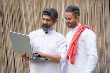 Technology concept. Two indian man using laptop