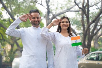 indian couple saluting tri color flag and celebrate national festival.