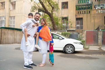 indian family standing outdoor and giving happy expression.