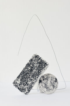 Speckled figures out of concrete and wire set on white background