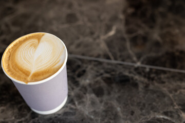 Close up of fresh cup of coffee on black countertop, copy space