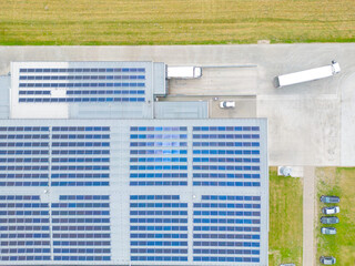 Fototapeta na wymiar Aerial view of modern storage warehouse with solar panels on the roof. Logistics center in industrial city zone from drone view. Background texture concept.