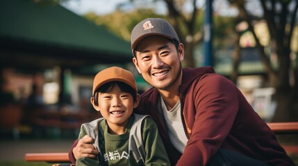 asian man and son with baseball cap at baseball stadium.