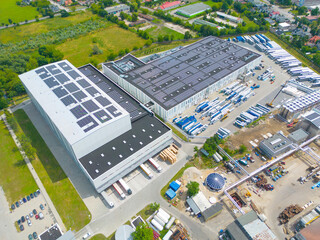 Aerial view of modern storage warehouse with solar panels on the roof. Logistics center in...