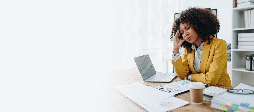 Burnout American African business woman in stress works with many paperwork document, migraine attack, Freelance, work at office
