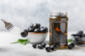 Delicious black olives. Pickled olives in glass jar. On a wooden background.Tasty olives. Close-up. Vegan.Place for text. copy space.