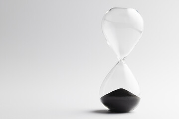 Close up of hourglass with black sand and copy space on white background
