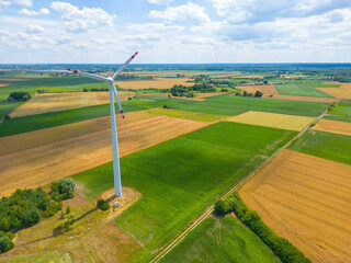 Aerial view of powerful Wind turbine farm for energy production on beautiful cloudy sky at highland. Wind power turbines generating clean renewable energy for sustainable development.