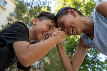 best friends in Uzbekistan enjoying there summer vacation in an outdoor park  playing games and the different expressions on their faces while playing in hot street make a friendship day special 
