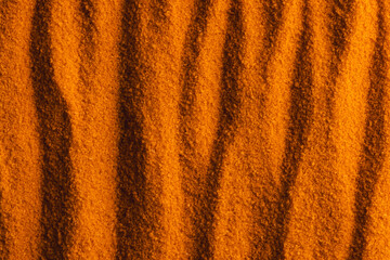 Close up of pattern of orange sand and copy space background