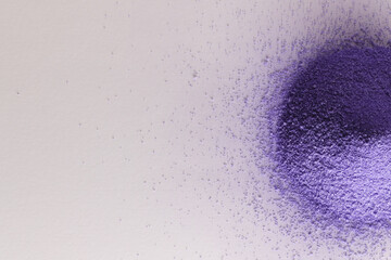 Close up of heap of purple sand and copy space on white background