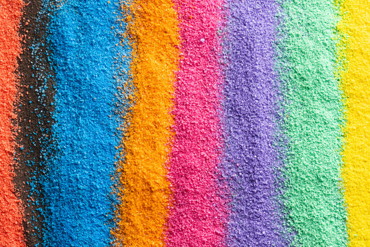 Close up of stripes of rainbow coloured sand and copy space background
