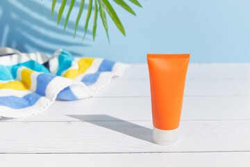 Sunscreen lotion on blue background. Care products summer beach accessories
