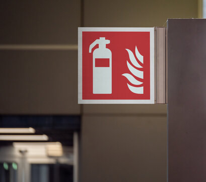 Close up of a red fire extinguisher sign on a wall. Selective focus image. Emergency sign, copy space for text and information.