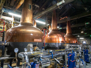 Industrial whiskey distiller construction, alcohol production factory interior background